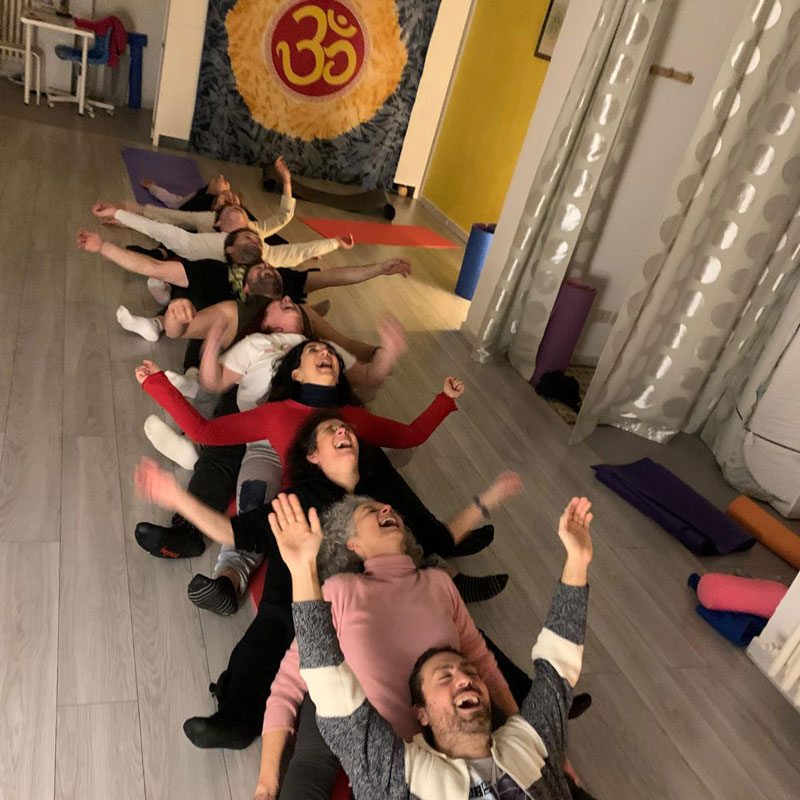 Yoga della risata persone che ridono distese a braccia aperte